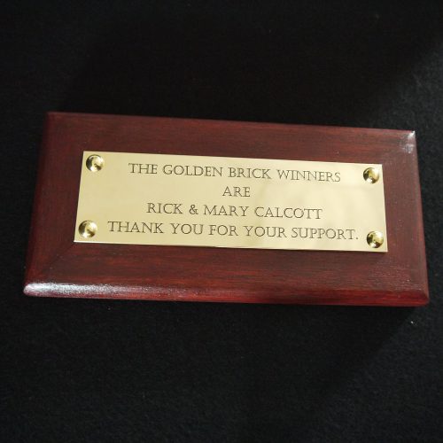 brass commemorative plaque on wooden backing